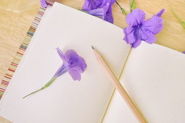beautiful purple flowers, notebook paper with pencil in vintage style. pastel filter.