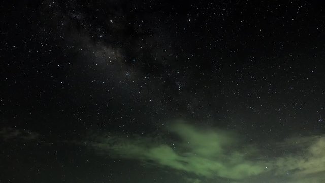 4k time lapse of milky way moving across the sky with light trails of airplane flying by.