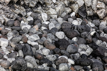 Rounded volcanic black stones on the beach of the Snaefellsjokull National Park on the Snaefellsnes peninsula in Iceland.