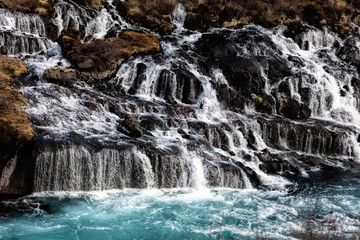 Obraz premium Hraunfossar in western Iceland is a series of waterfalls formed by rivulets streaming out of the Hallmundarhraun lava field.