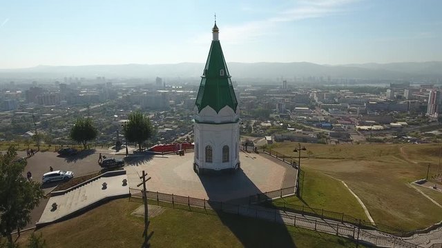 Paraskeva pyatnitsa chapel Orhtodox Friday symbol of Krasnoyarsk. Top of Karaulnaya Mountain pagan Tatar temple. Russian old architecture. Observation deck. Aerial drone forward flight to city center