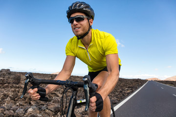 Cyclist man biking riding road bike training for triathlon. Biker on cardio workout on open road....