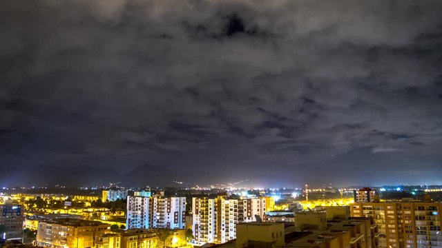Clouds over city in the night timelapse