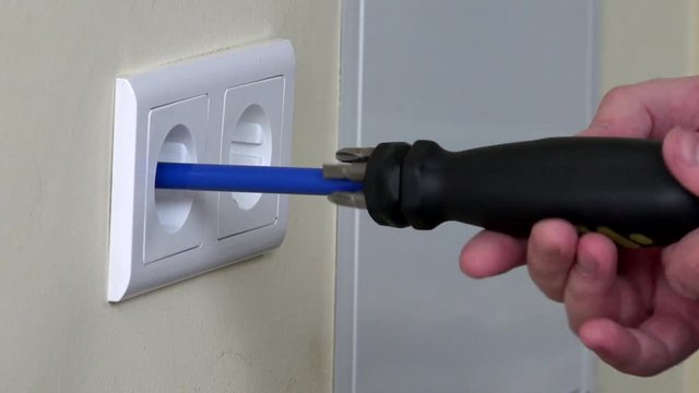 Electrician hands installing electrical wall sockets
