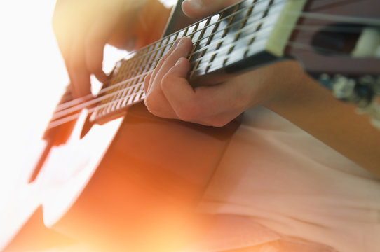 Close up of young girl playing acoustic guitar