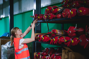 Checking fire extinguishers in the warehouse. Woman Engineer shall record and verify the presence...