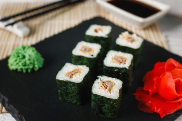 Tasty delicious set of sushi rolls with eel served on black slate, closeup. Traditional Japanese seafood, Asian cuisine.