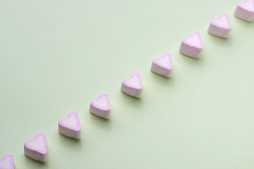 Valentines Day candy hearts marshmallows over green background