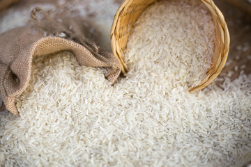 White uncooked rice on wooden surface.