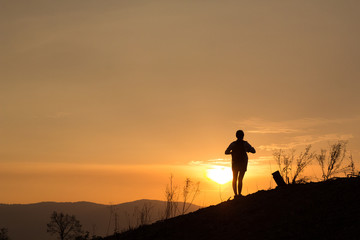 Woman backpacking to watch the sunset.Silhouette