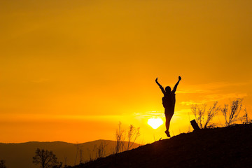 Woman backpacking to watch the sunset.Silhouette,Jumping glad