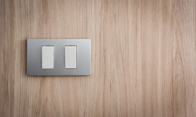 Close up grey light switch on wooden background. Copy space.