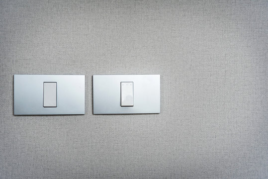 Close up grey light switches on texture background. Copy space.