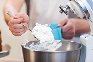 Fototapeta premium Close-up of a man's hand puts a cream in a confectionery syringe
