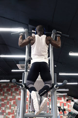 Fototapeta na wymiar black man doing exercises pull ups