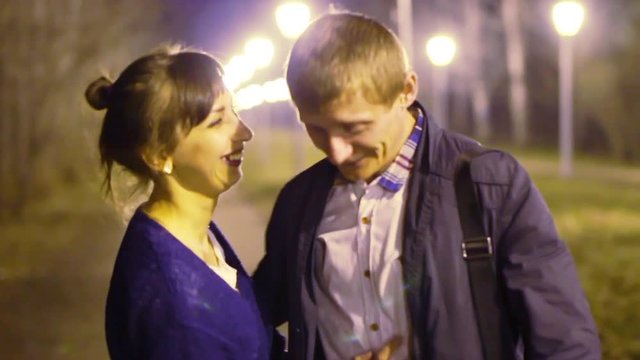 A guy and a girl talk and walk around the night city
