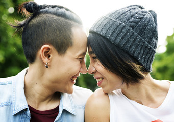 Close up of smiling young couple touching head outdoors