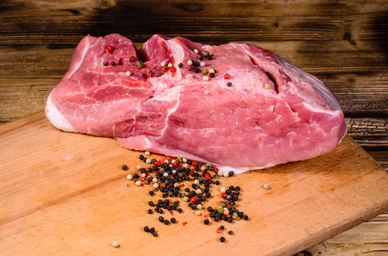Raw pork meat and different spiceson cutting board