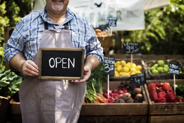 Greengrocer selling organic fresh agricultural product at farmer market