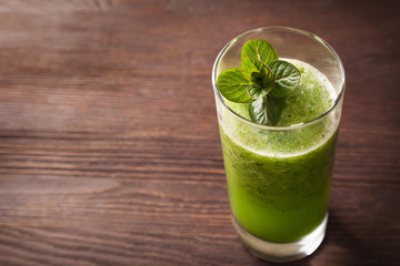 Smoothies green dietary vegetarian on a wooden table with mint leaf