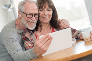 Modern mature couple using tablet