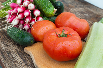juicy red tomato, radish, cucumber on a wooden background