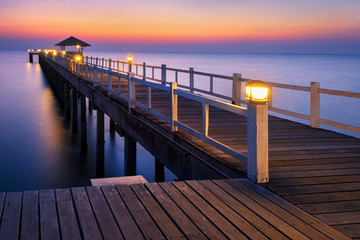 Fototapeta na wymiar wood bridge to the sea at sunset.