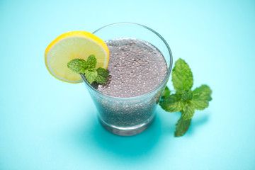 Selective focus of chia seeds drink with water in transparent glass with lemon balm.