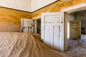 Orange room full of sand in the diamond ghost town of Kolmanskop in Namibia, Africa