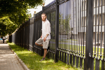 Cool bearded hipster posing outside in the city. Style and diversity