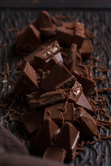 Milk chocolate. Milk chocolate pieces on a wooden background