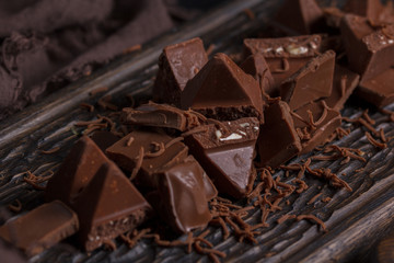 Milk chocolate. Milk chocolate pieces on a wooden background