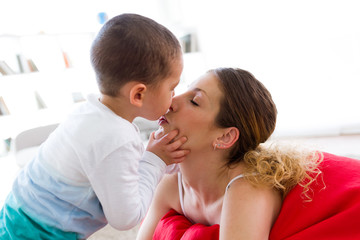 Beautiful young mother and her son having fun at home.