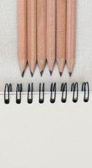 Pencil , notebook on tablecloth