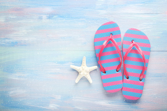 Flip flops with starfish on a blue wooden table