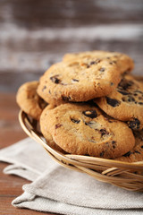 Chocolate chip cookies in basket on brown wooden table