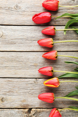 Red tulips on grey wooden table
