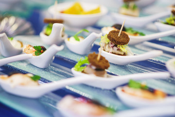 Light snacks and canaps, seafood, shrimp, olives on Japanese spoons for miso soup. 