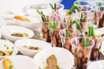 Light snacks and canaps, seafood, shrimp, olives in small glasses.