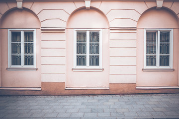 Old classical building wall with windows and pavement as as architectural background