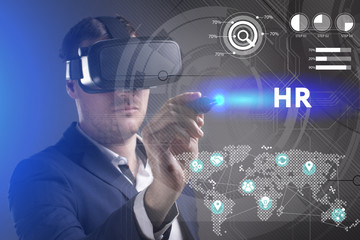 Business, Technology, Internet and network concept. Young businessman working in virtual reality glasses sees the inscription: HR