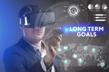 Business, Technology, Internet and network concept. Young businessman working in virtual reality glasses sees the inscription: Long term goals