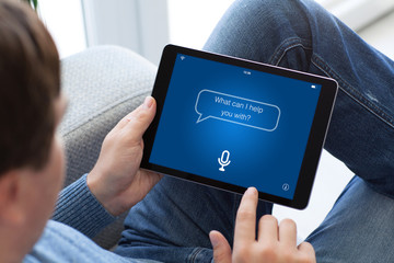 man in jeans holding tablet with app personal assistant screen