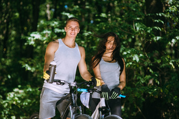 Young Couple Riding Bike In Park