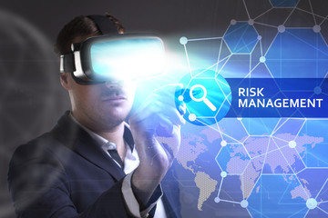 Business, Technology, Internet and network concept. Young businessman working in virtual reality glasses sees the inscription: Risk management