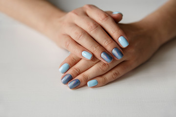 Natural nails with beautiful manicure, blue polish on women nails