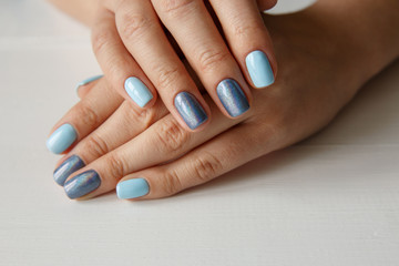 Natural nails with beautiful manicure, blue polish on women nails