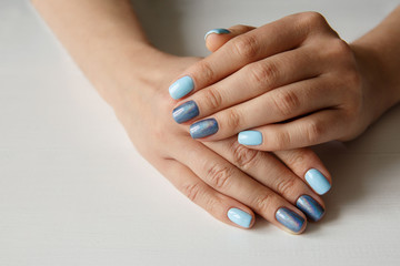 Obraz na płótnie Canvas Natural nails with beautiful manicure, blue polish on women nails