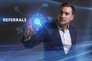 Business, Technology, Internet and network concept. Young businessman working on a virtual screen of the future and sees the inscription: Referrals