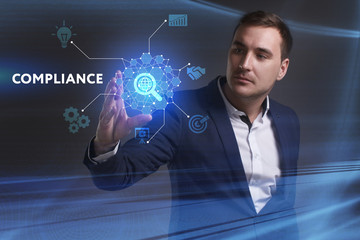 Business, Technology, Internet and network concept. Young businessman working on a virtual screen of the future and sees the inscription: Compliance